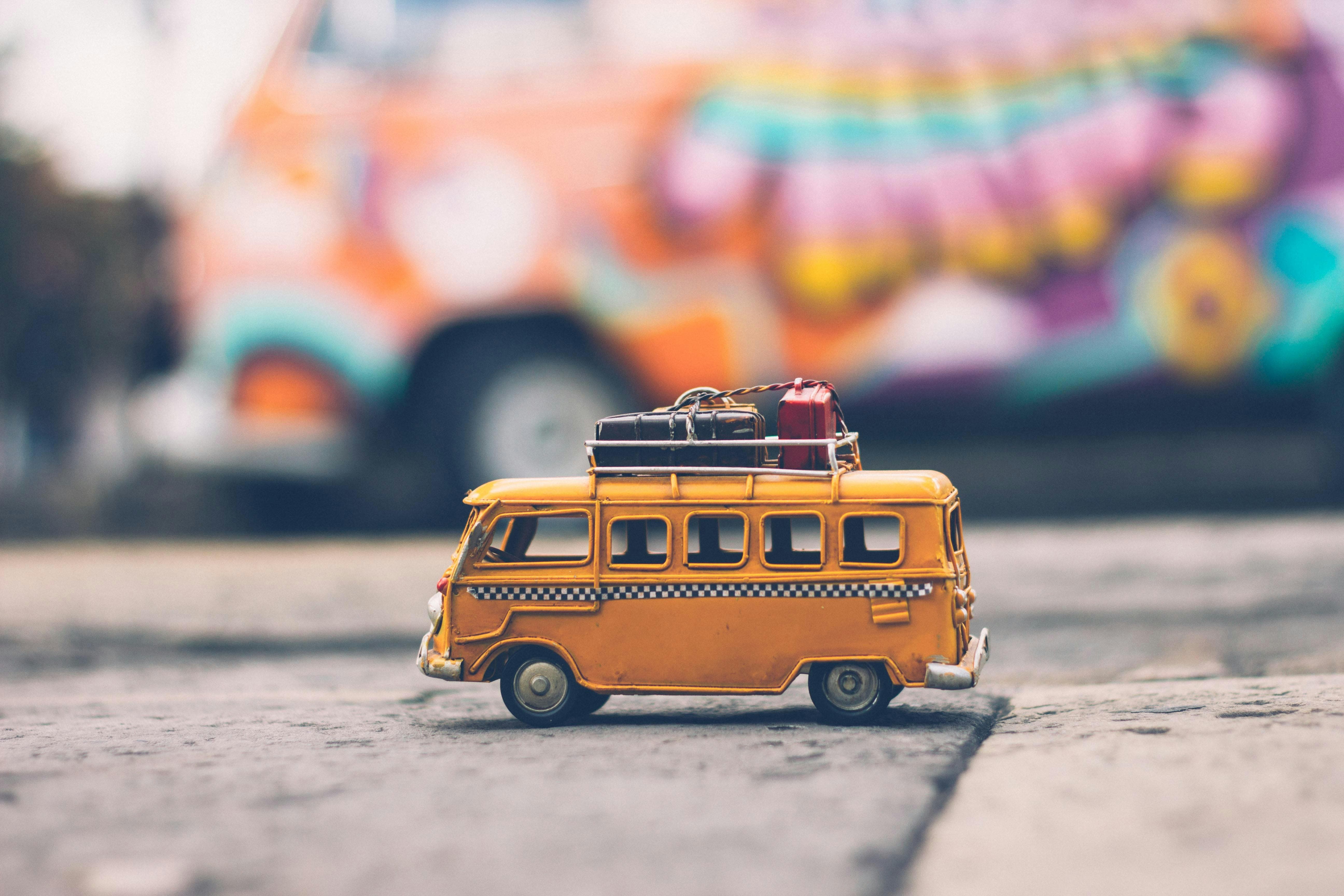 Miniature yellow van with luggage on top, symbolizing packing for a Monteverde trip