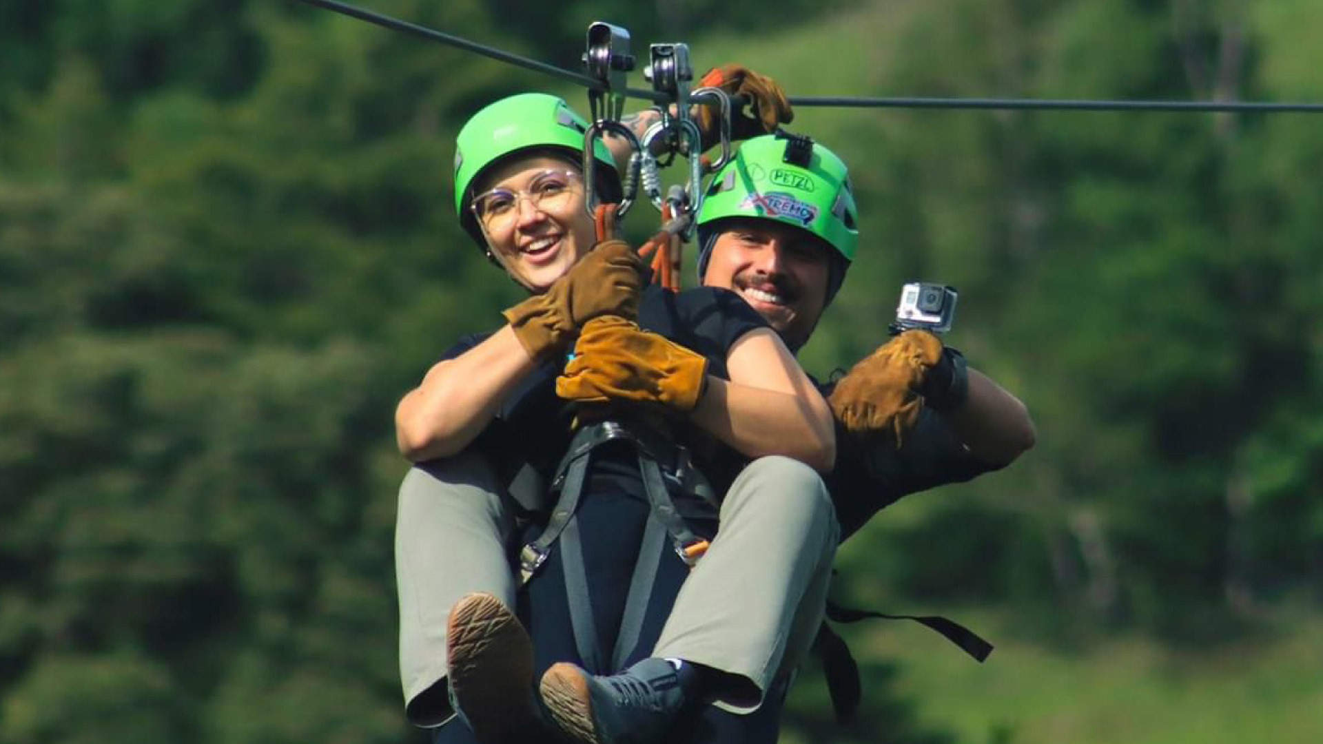 Couple ziplining together during the Night Walk tour at Extremo Park, Monteverde, Costa Rica