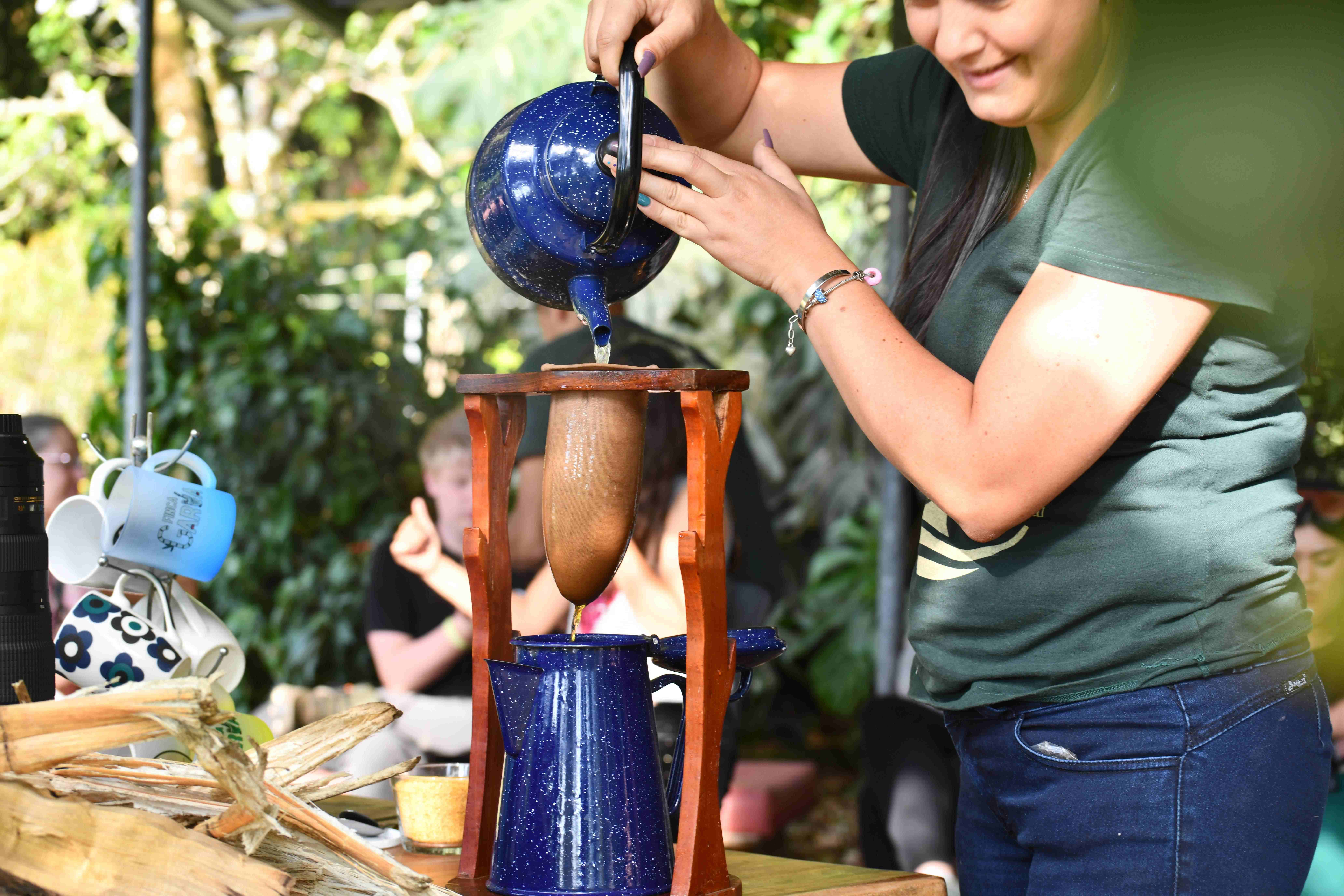 Mujer sirviendo café artesanal usando filtro de tela tradicional en Finca Garúa.