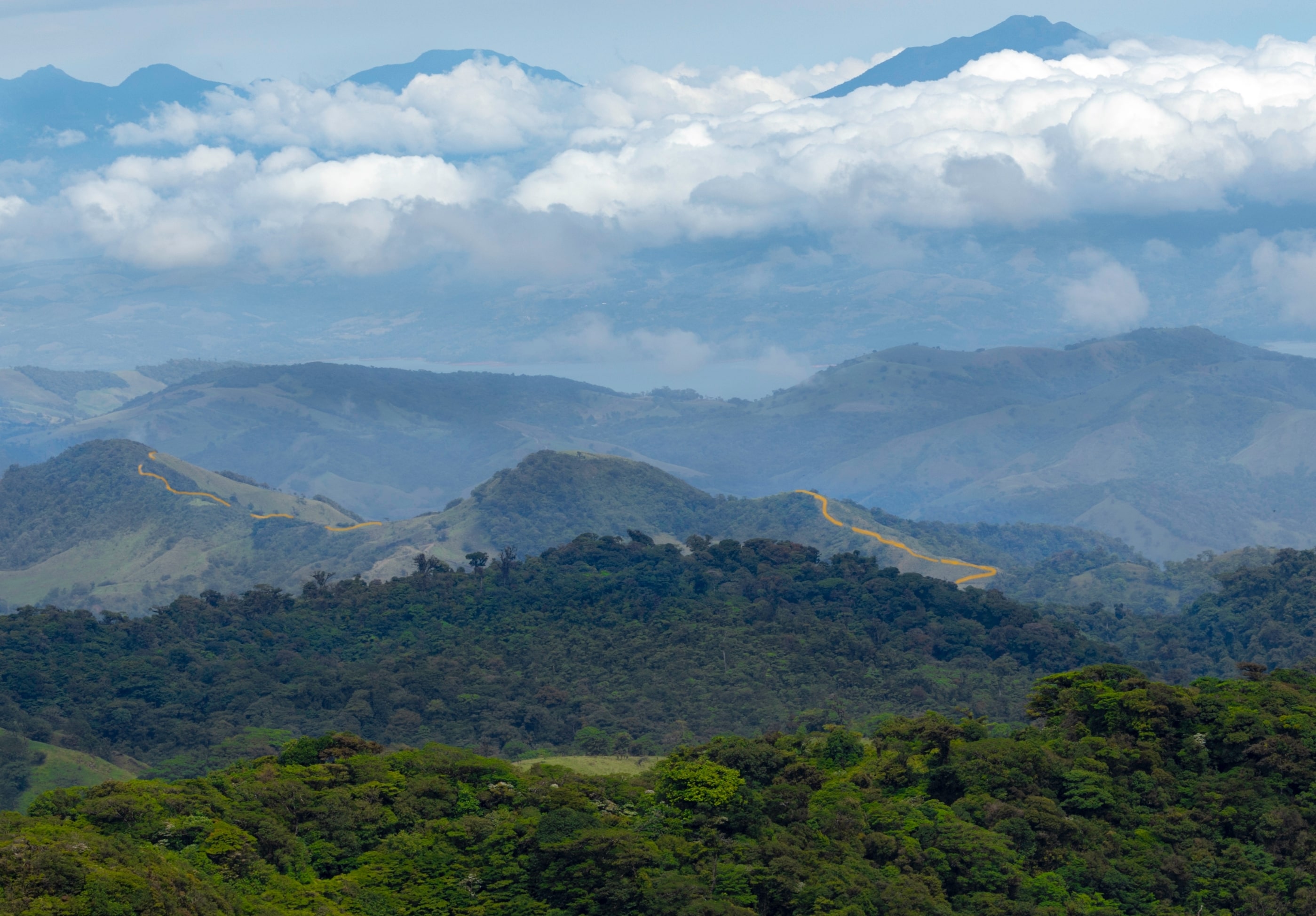 View of Monteverde mountains, Costa Rica, with a blue sky and white clouds creating a stunning contrast.